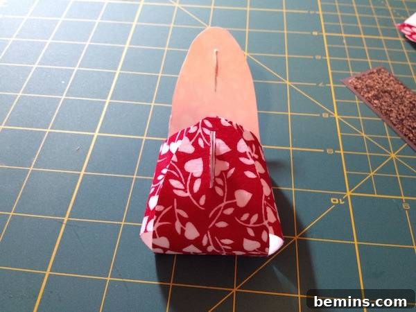 A piece of cardboard is covered by a red bandana on top of a green and orange grid.