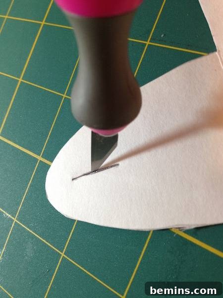 A person cutting fabric for gift box preparation with knife.