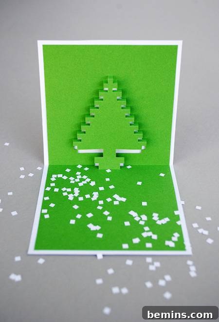 A folded Christmas card with a paper Christmas tree in it.