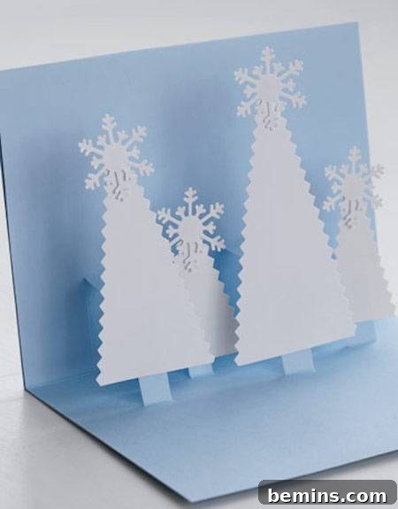 A blue card with white pop up trees lies open.