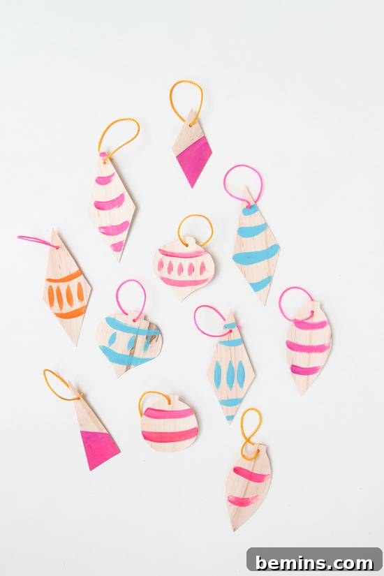 Vibrantly painted veneer ornaments showcasing diverse patterns and color combinations, laid out to dry.