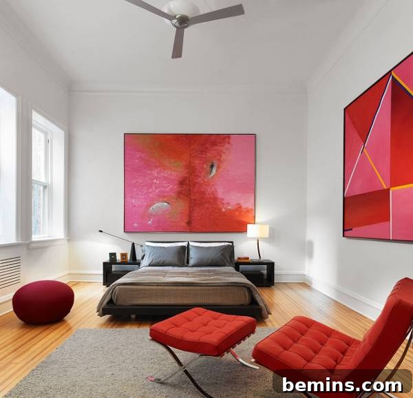 Pink Power: 16 Dreamy Bedrooms for the Bold at Heart 12 A red chair and a black bed sit in a white room with red paintings.