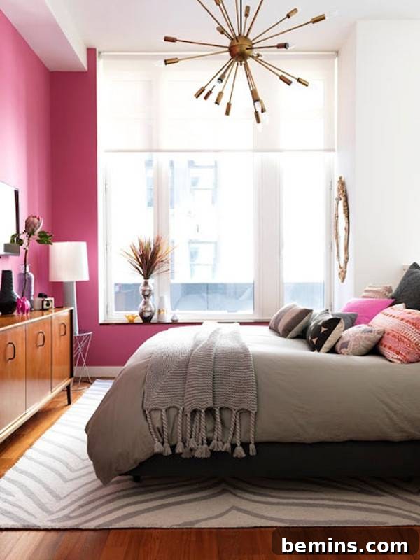Pink Power: 16 Dreamy Bedrooms for the Bold at Heart 15 Pink bedroom with bed and designer pillows, cabinet, lamp, and chandelier.