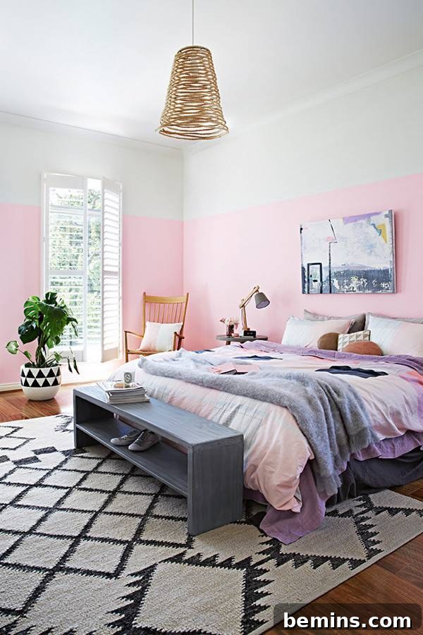 Pink Power: 16 Dreamy Bedrooms for the Bold at Heart 4 A pink bedroom with a bed made in a pink cover with a grey throw and a grey shoe bench at the base of the bed.