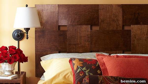 Unique DIY Headboard Designs to Reinvent Your Bedroom 17 A bed with yellow and orange colored pillows next to a nightstand that has roses and a white lamp.