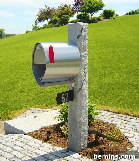 Sleek stainless steel Spira mailbox with a newspaper cubby and red flag.