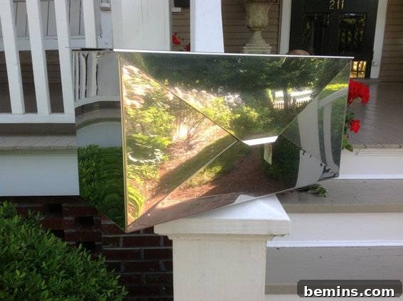 Modern stainless steel 'envelope' style wall-mounted mailbox.