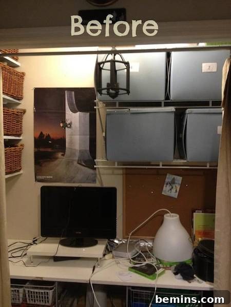 A cluttered closet before renovation, showing a computer monitor on a desk with a white lamp and light blue storage containers, a space one might want to hide.