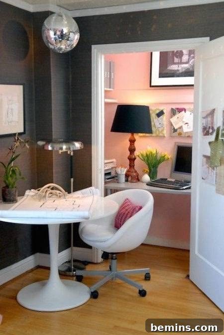 A white chair and table in a grey room, featuring a closet cleverly used as a credenza or office space, famously accented with a fun disco ball, adding personality and flair.