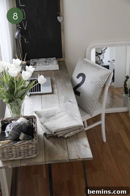 A rustic home office with a weathered wooden desk and striped pillow