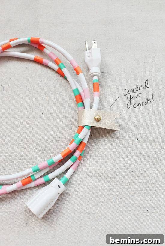 A wrapped up computer cord is covered in orange white and teal crochet yarn.