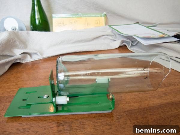 Which Bottle Cutter Reigns Supreme? A Definitive Review 29 Cut bottle positioned horizontally in a green bottle cutter that sits on a wooden surface.