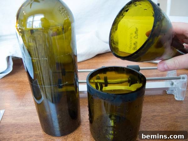 Which Bottle Cutter Reigns Supreme? A Definitive Review 41 A hand holding top part of a glass bottle while the bottom part is lying near another glass bottle.