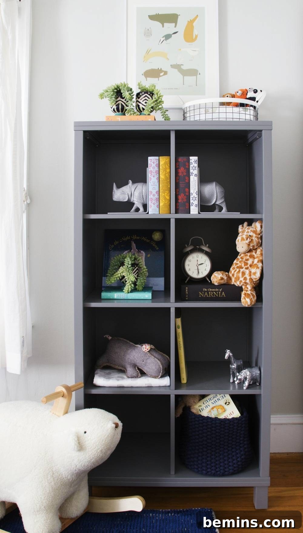 A sleek, dark gray shelving cabinet in a contemporary room, meticulously organized with a variety of objects including books, toys, and decorative items, showcasing practical and stylish storage solutions.