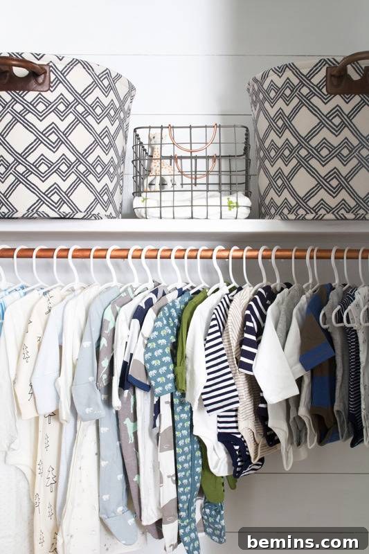 An organized nursery closet with storage boxes neatly placed in the upper section and baby dresses charmingly hung on a copper pipe rack in the lower portion, maximizing space and style.