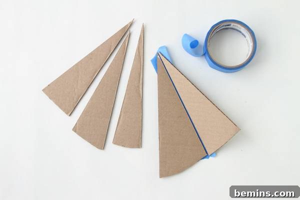 DIY Geometric Concrete Bookends from Recycled Cardboard 7 Cardboard triangles attached with blue tape.