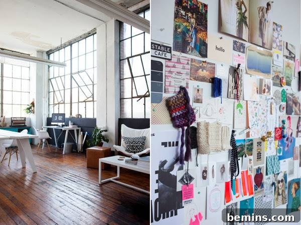 Loft with wall of windows and wooden furniture with a collage of papers on wall. Emma Dime's studio features a Scandinavian-inspired aesthetic.