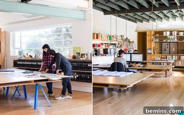 People are working in a room with tables and wooden floors. March Studio Design Office showcases an industrial chic aesthetic.