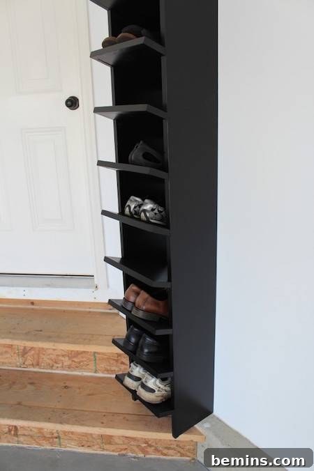 A tall black shelf filled with shoes, demonstrating a practical and organized shoe storage solution for the garage.