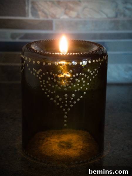 Craft an Elegant Inverted Wine Bottle Oil Lamp 13 The finished wine bottle oil lamp, lit and radiating a soft, ambient glow, highlighting its intricate metallic dot pattern.