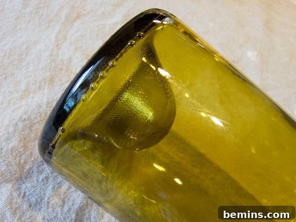 Craft an Elegant Inverted Wine Bottle Oil Lamp 3 A close-up view of the base of a glass wine bottle, clearly showing a deep punt, which is essential for the inverted oil lamp design.