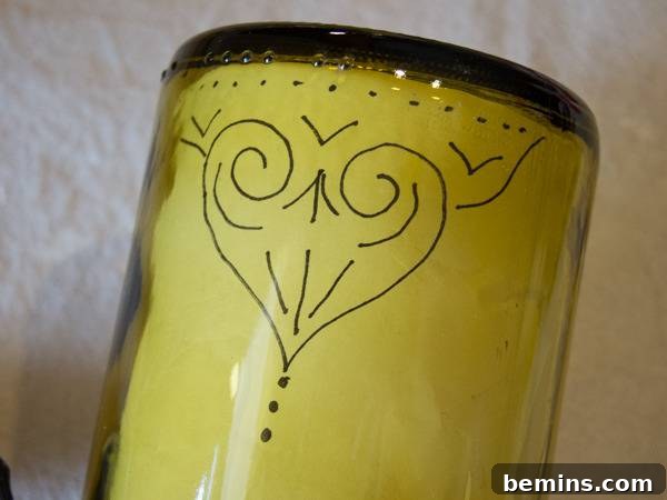 Craft an Elegant Inverted Wine Bottle Oil Lamp 6 A sketched design taped securely inside the inverted wine bottle, serving as a guide for applying paint.