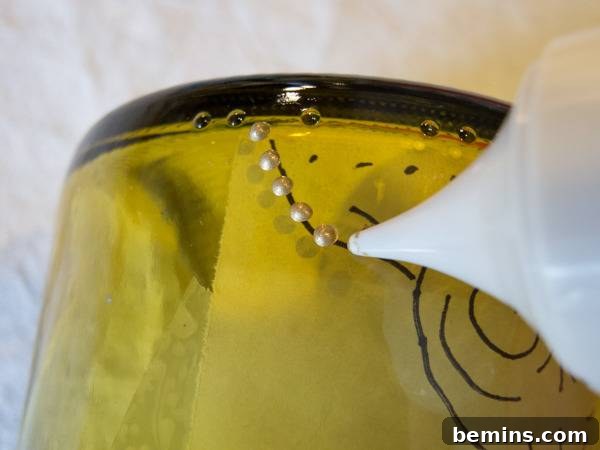 Craft an Elegant Inverted Wine Bottle Oil Lamp 7 A person meticulously applying delicate metallic paint dots onto the glass bottle, following the internal design template.