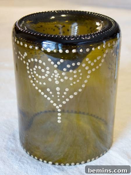 Craft an Elegant Inverted Wine Bottle Oil Lamp 8 The cut wine bottle, now beautifully adorned with a completed metallic dot pattern, awaiting the paint to dry fully.