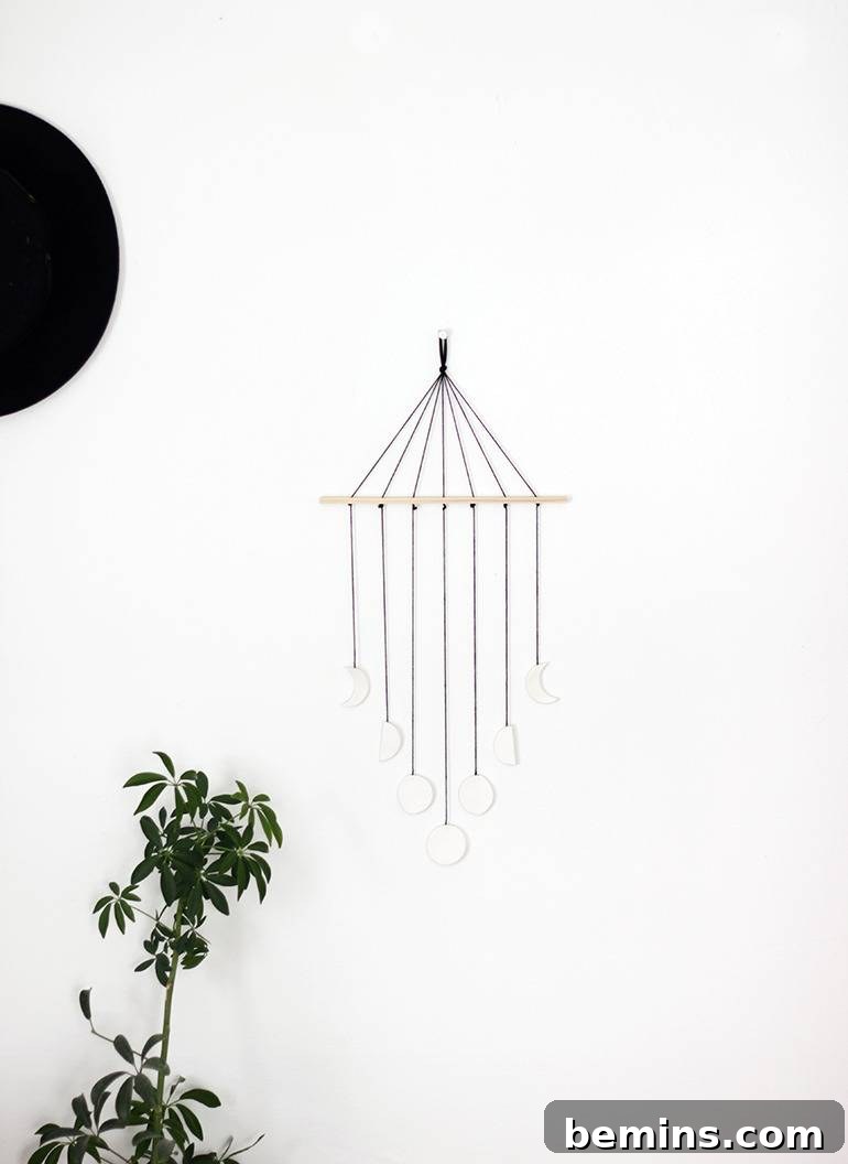 A DIY moon phase wall mobile adding a celestial and whimsical touch to a room.