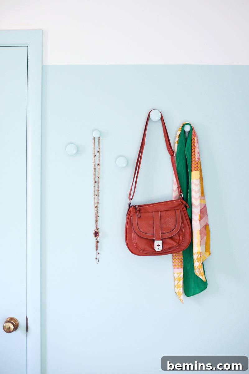 Stylish drawer knobs repurposed as unique and functional wall hooks, adding a touch of elegance to a white wall.