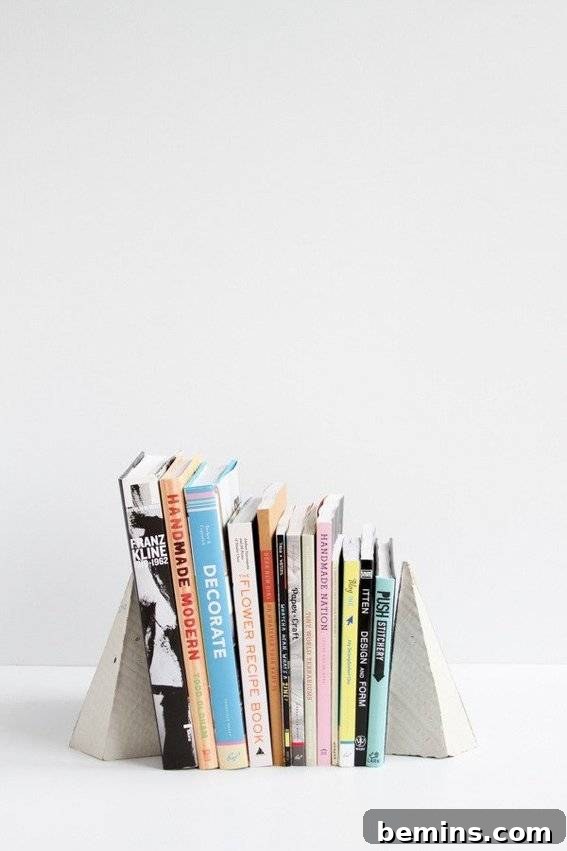 Geometric concrete bookends adding a modern and industrial touch to a bookshelf.