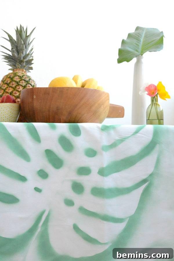 DIY Tropical Leaf Tablecloth Project 11 Fruits, a bowl, and a flower in a bottle arranged beautifully on the tropical tablecloth.
