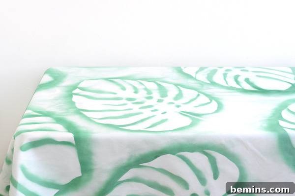 DIY Tropical Leaf Tablecloth Project 9 A white tablecloth adorned with green tropical leaf designs.