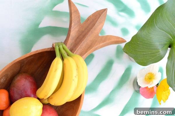 DIY Tropical Leaf Tablecloth Project 10 Fresh fruit displayed in a decorative wooden basket, complementing the tropical theme.