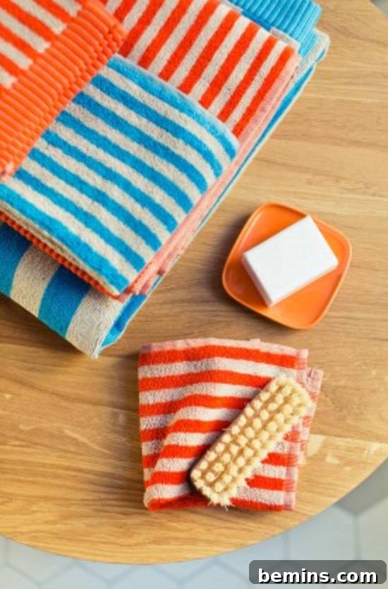 Folded linens with scrub brush and bar of soap, showcasing Ujo Guest Towels