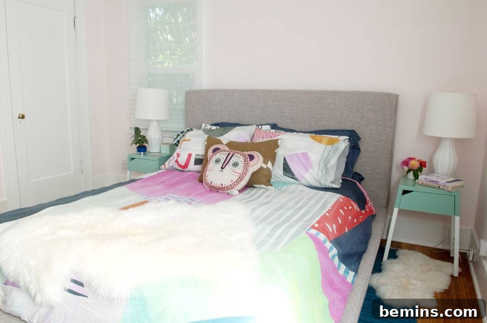 Close-up of a bed with a grey headboard and colorful decorative pillows, including an animal-shaped pillow.