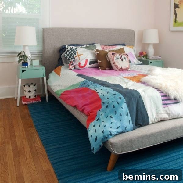 Revamped Radiance: A Nightstand's Bold Transformation 5 A bed with colorful sheets is sitting on a blue rug in a room with wooden flooring.