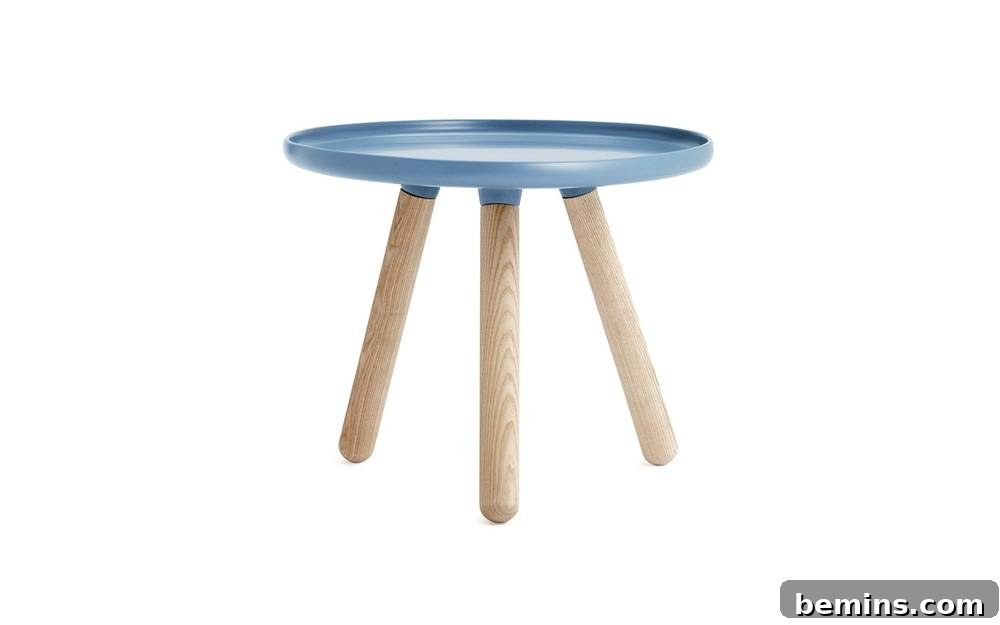 From Bland to Brilliant: 13 Colorful Bedroom Decor Ideas 4 A stylish blue side table with three wooden legs offers a modern and colorful alternative to traditional nightstands.