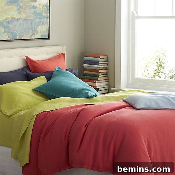 From Bland to Brilliant: 13 Colorful Bedroom Decor Ideas 7 Colorful bedding from Crate and Barrel featuring red and yellow sheets with purple, orange, and teal pillows creates a vibrant and inviting sleep space.
