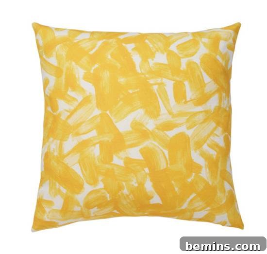 From Bland to Brilliant: 13 Colorful Bedroom Decor Ideas 8 A yellow and white abstract patterned throw pillow from Dwell Studio adds a touch of modern art and comfort to any bedroom decor.