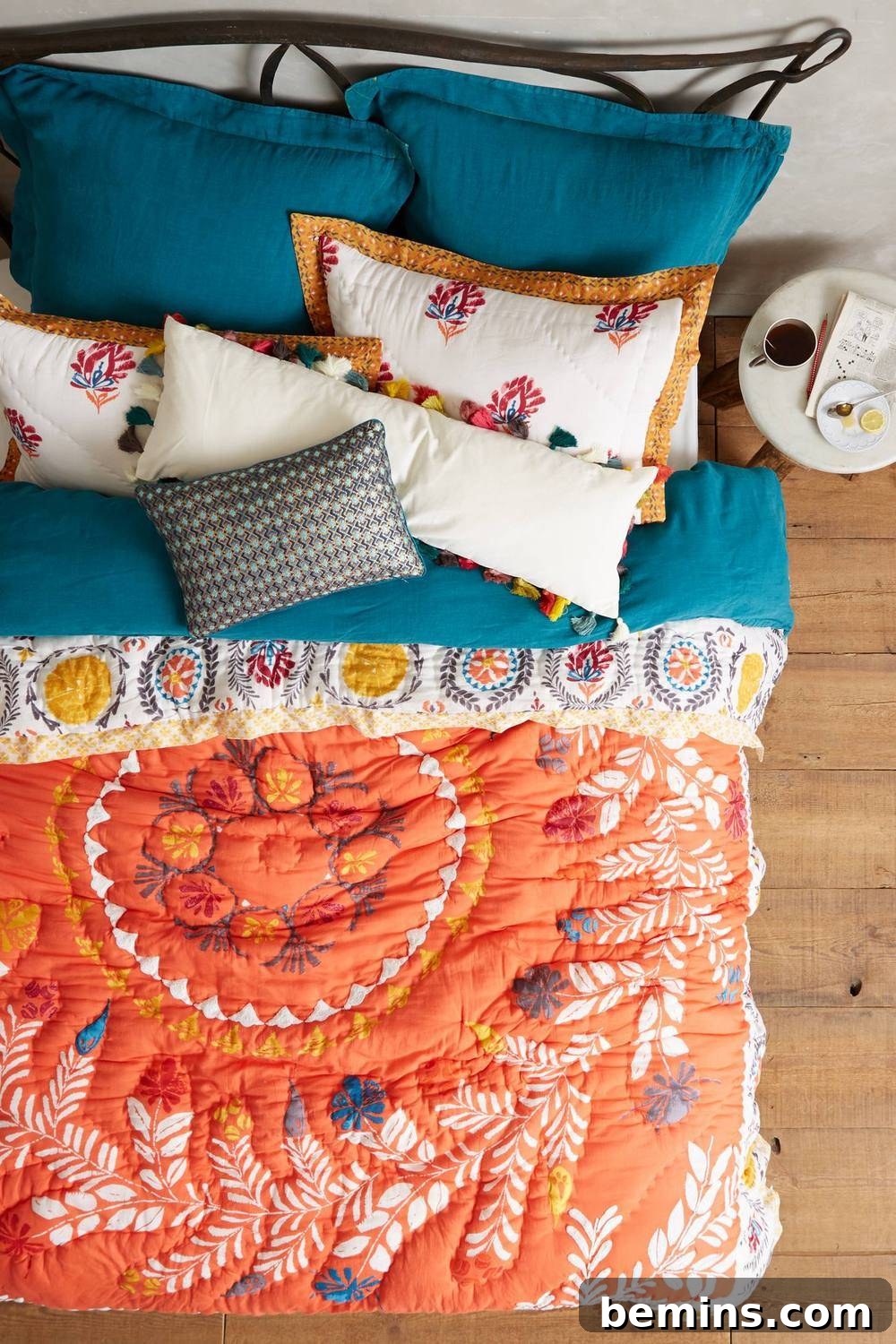 From Bland to Brilliant: 13 Colorful Bedroom Decor Ideas 10 A color-packed comforter from Anthropologie creates a vibrant and inviting bed, instantly transforming the room's atmosphere.