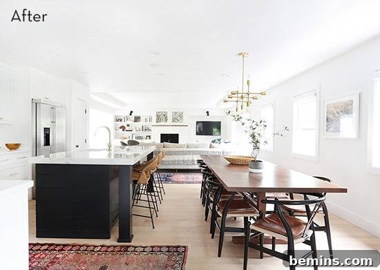 A pristine white kitchen featuring a large island and a substantial wooden dining table, showcasing a modern and elegant 'after' transformation.