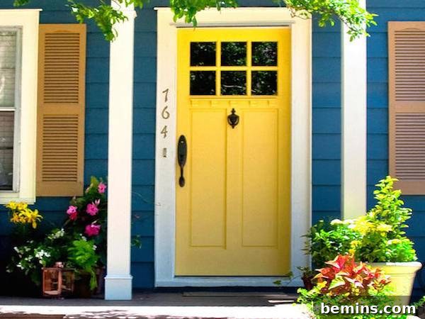 A vibrant yellow door contrasting beautifully with the blue facade of the house, creating a striking and cheerful contrast.
