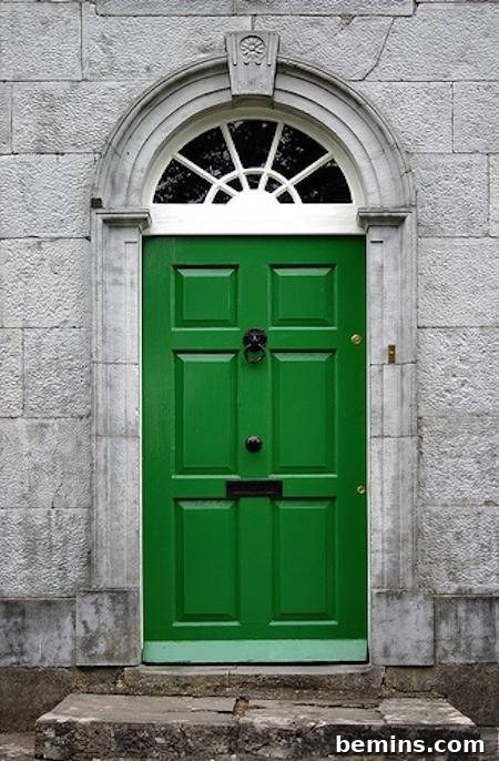 A stone porch featuring a green front door, creating a natural and inviting entrance.