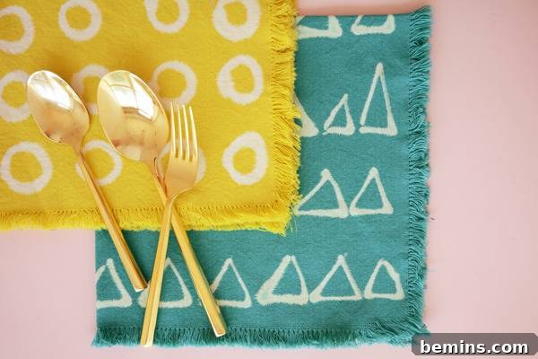 DIY Bleach Stenciled Geometric Napkins 10 Golden silverware on top of yellow and turquoise place mats.