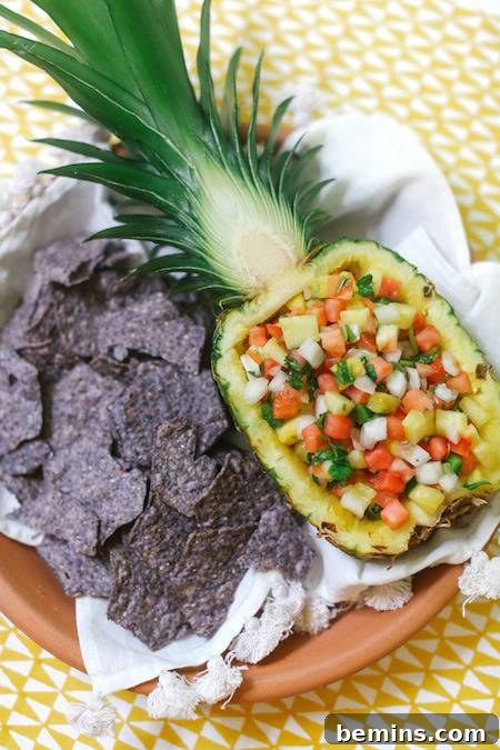 A pot with an open pineapple full of little fruits