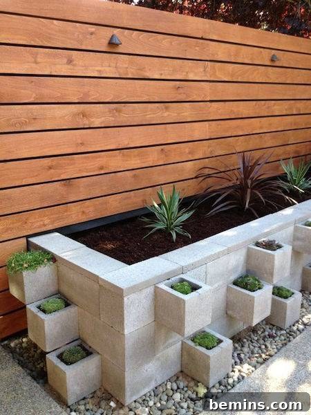 Concrete planter pots jut out of a large concrete planter on a patio.