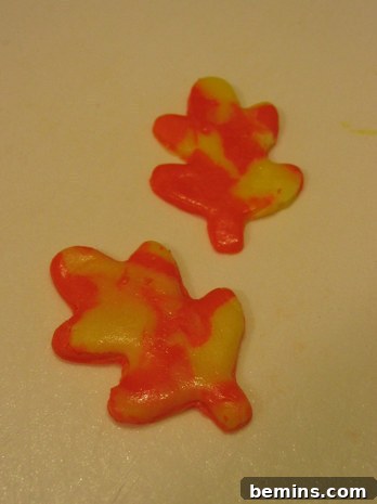 Two yellow and orange candy corn fondant decorations.