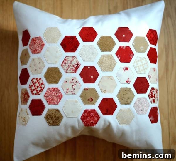 Modern Hexagon Quilt: A Geometric Masterpiece 3 A white pillow with colorful hexagon patterns, showcasing the versatility of hexie designs.