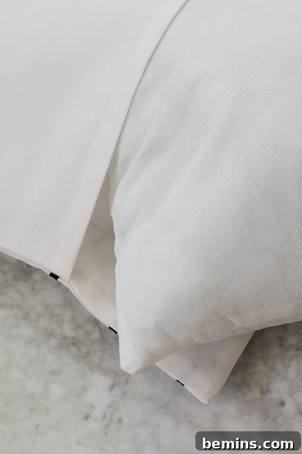 Stylish Geometric Pillows Easy DIY Guide 16 Two finished geometric grid pillows, one in black and one in white, placed elegantly on a bed, showcasing their modern appeal.